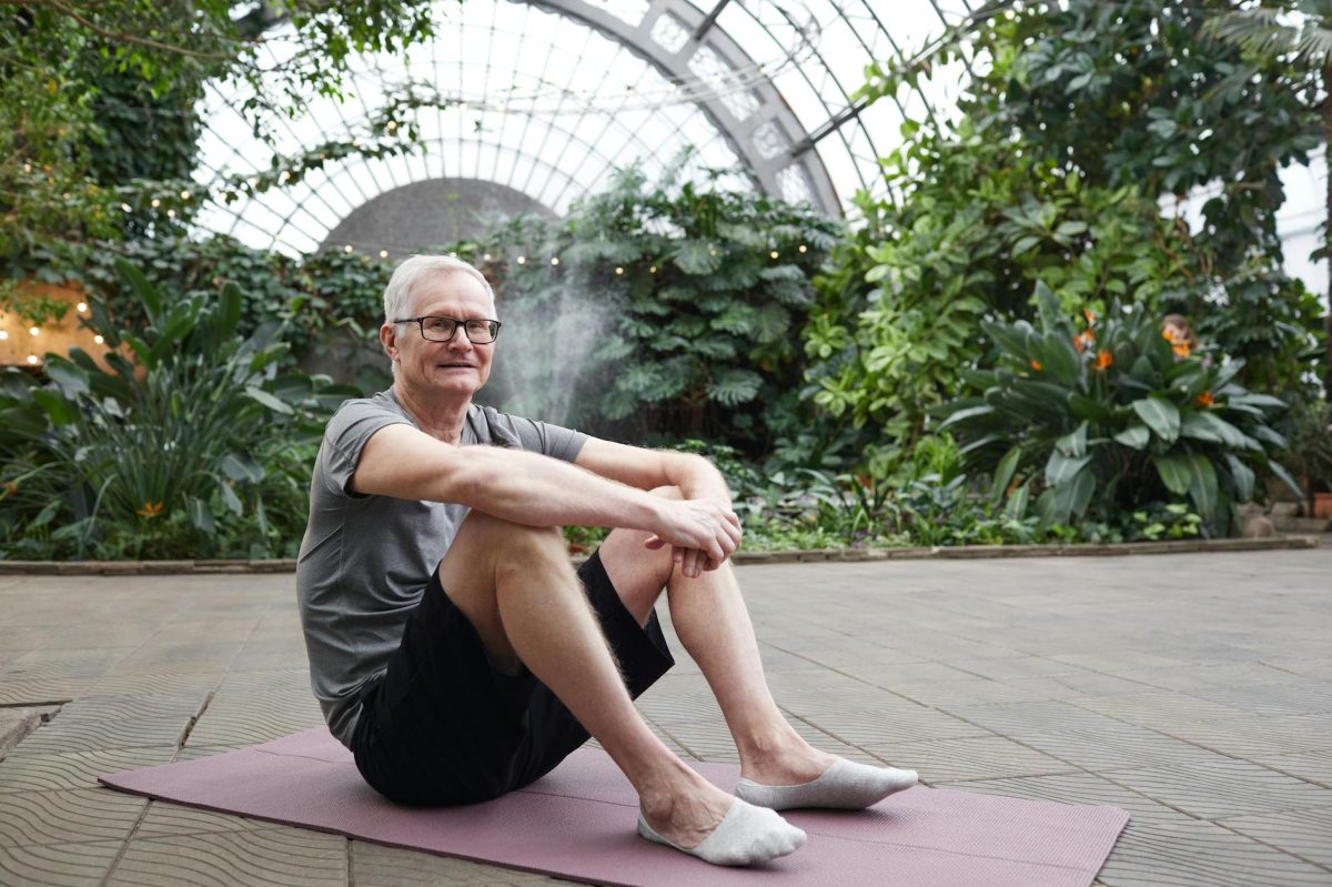 man sitting on yoga mat